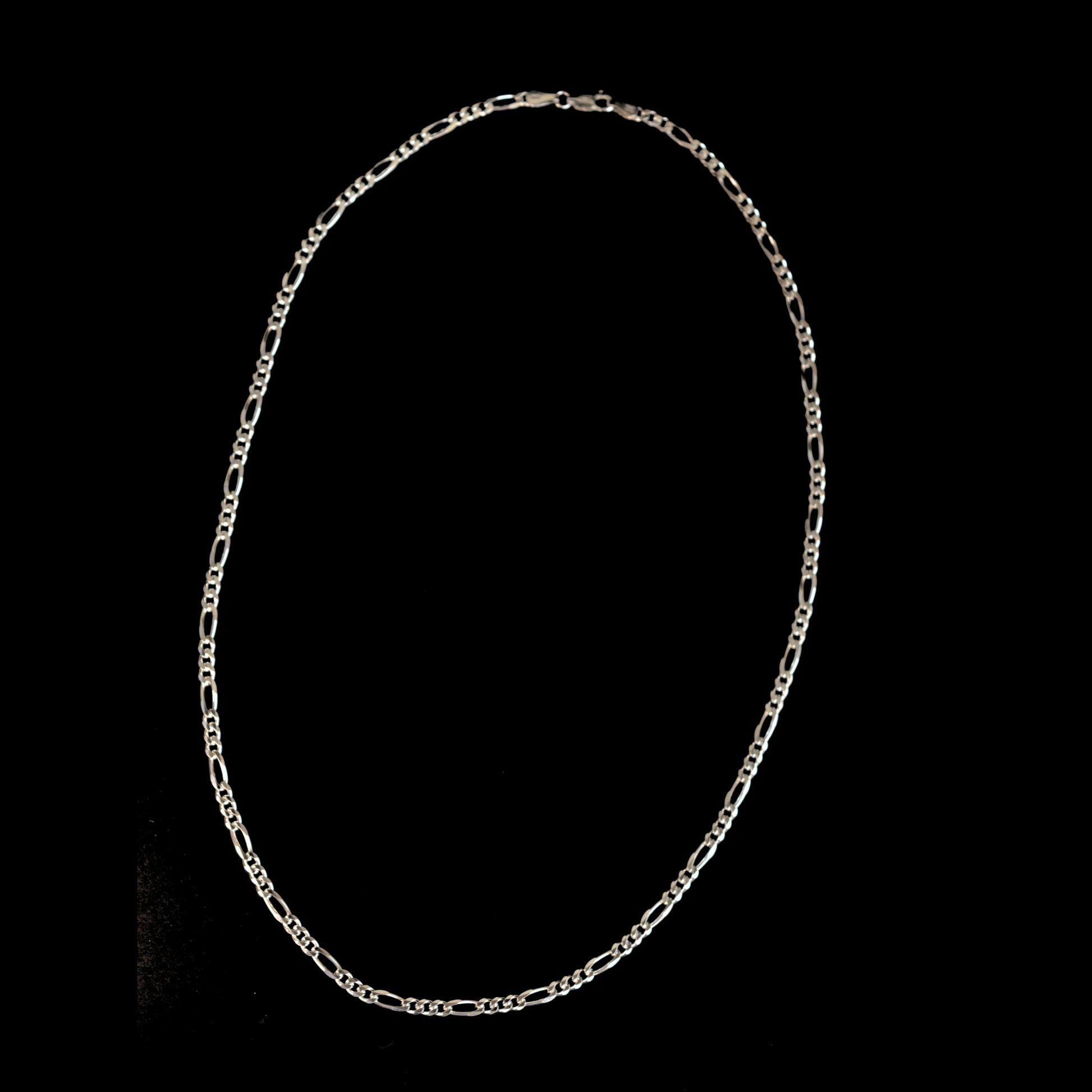 A minimalist, polished silver circular chain featuring a sleek, modern aesthetic suitable for all genders, isolated on a black background