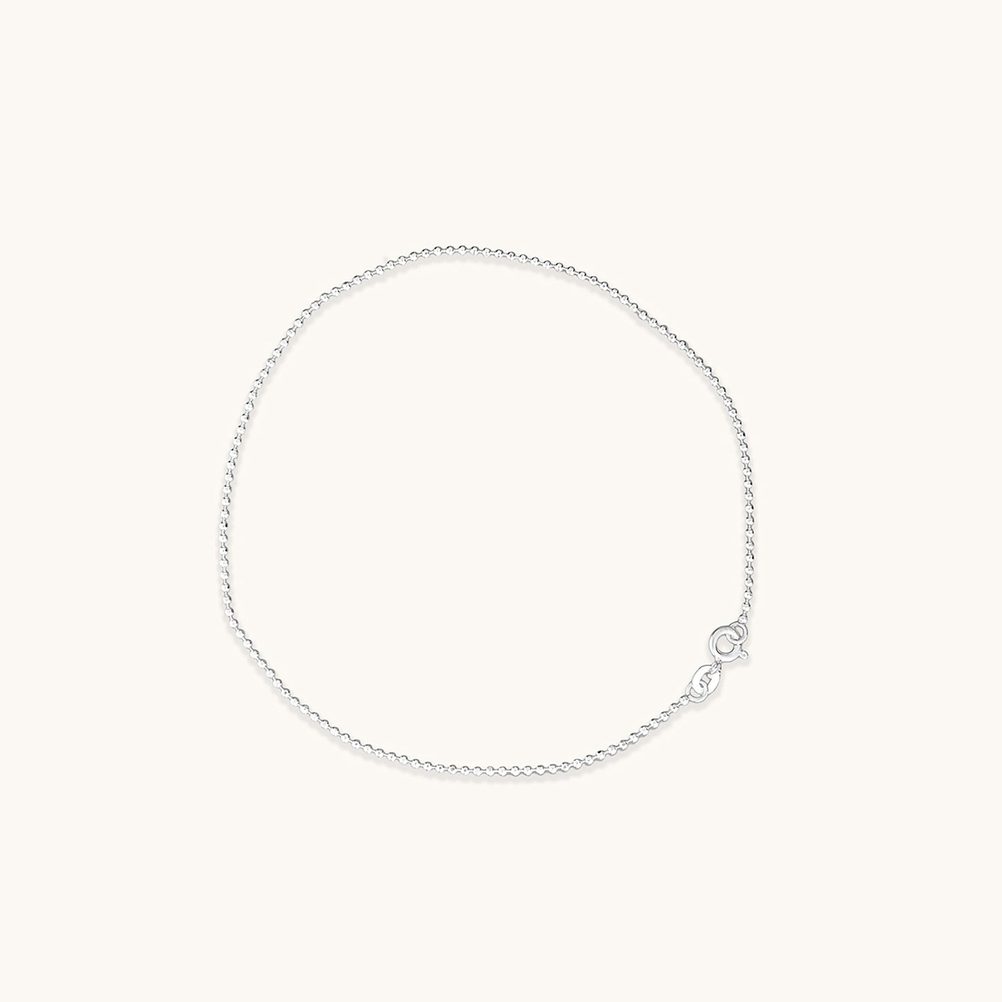 Minimalist silver chains decorated with small, uniform beads, displayed in a circular arrangement.