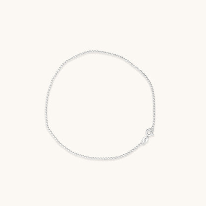 Minimalist silver chains decorated with small, uniform beads, displayed in a circular arrangement.