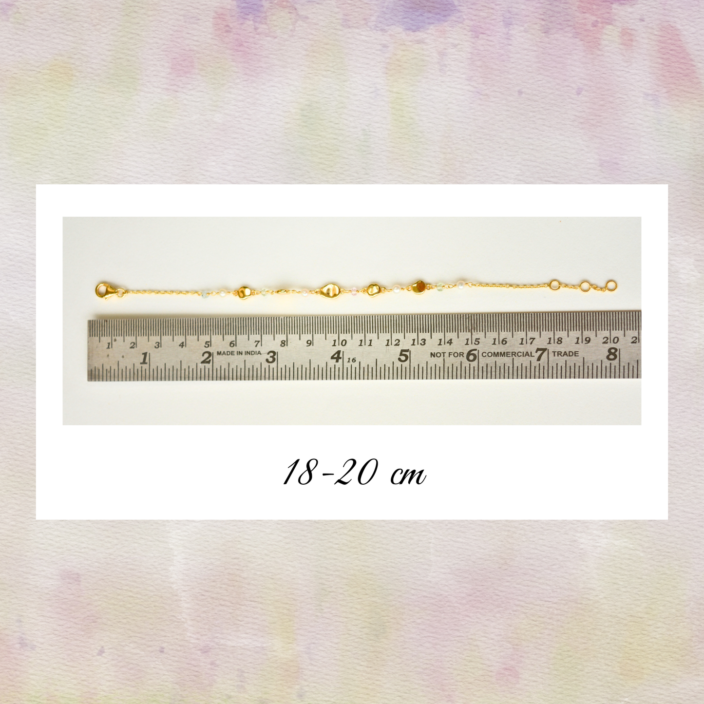 A flat-lay view of a gold-toned silver bracelet aligned against a metal ruler showing a length of 18-20 cm.