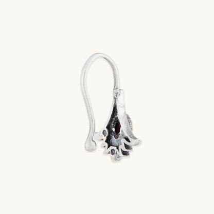 A side-profile view of a detailed silver-toned clip-on nose accessory, highlighting an ornate floral metal frame and a polished, translucent amber-hued stone.