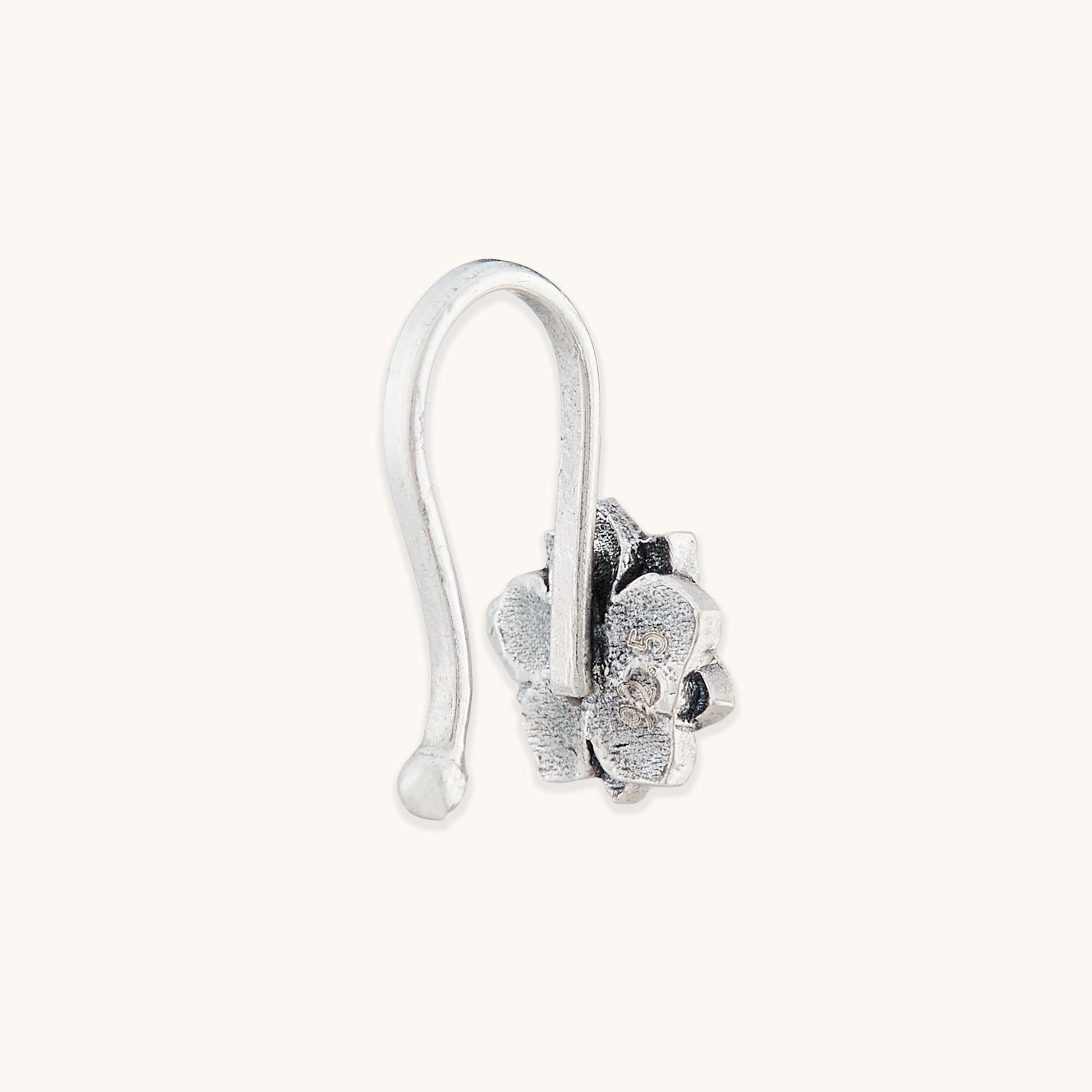 A side profile view of a silver-toned nose clip showing a 925 metal hallmark, featuring an ornate floral frame.