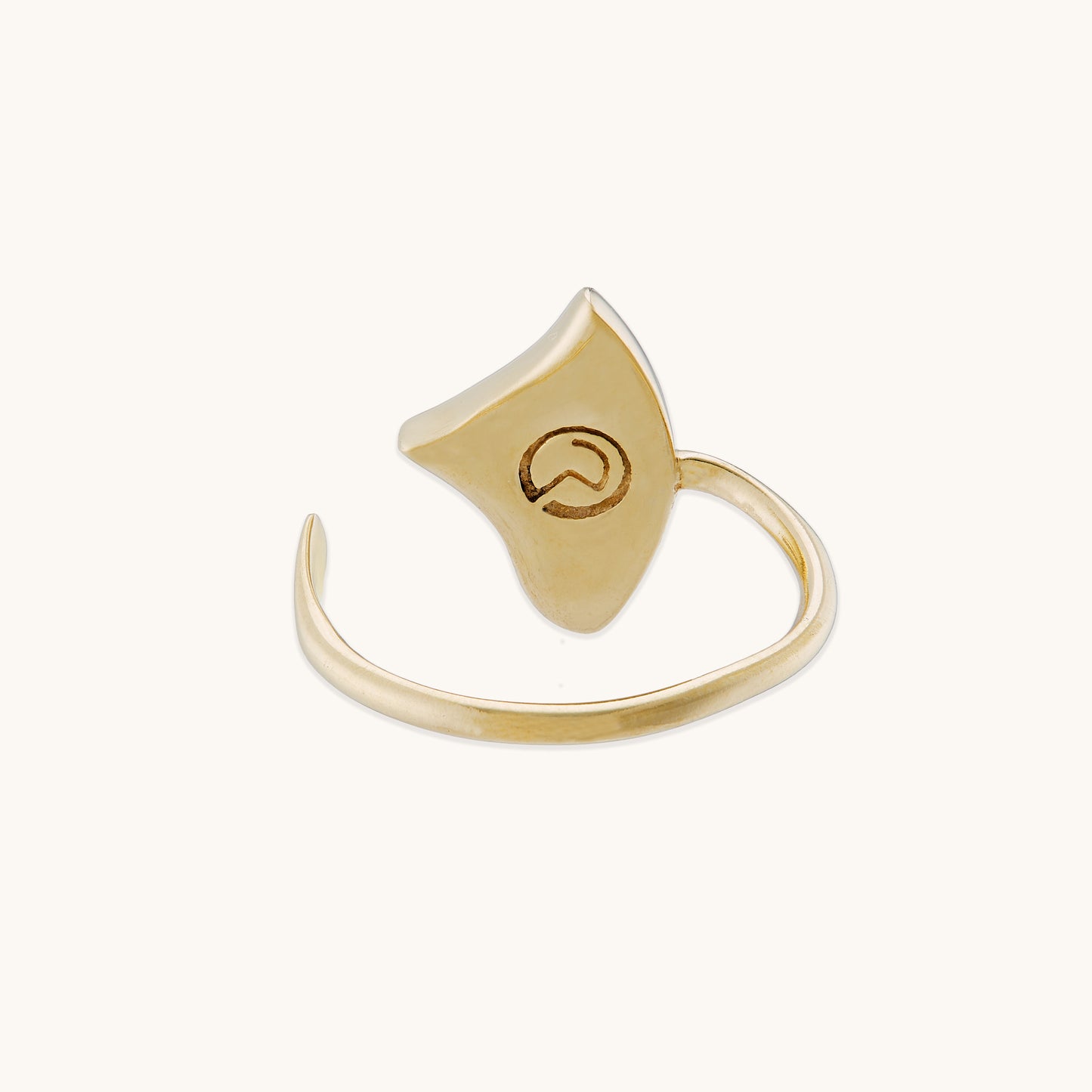 Back view of a gold-tone open-band ring featuring an engraved circular logo on the underside of the gemstone setting.