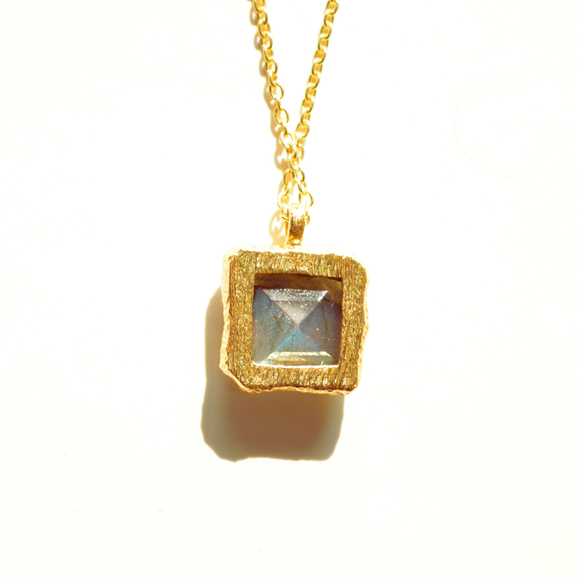 Back view of elegant sterling silver gemstone necklace piece featuring a natural, shimmering labradorite stone, highlighted against a clean studio backdrop.