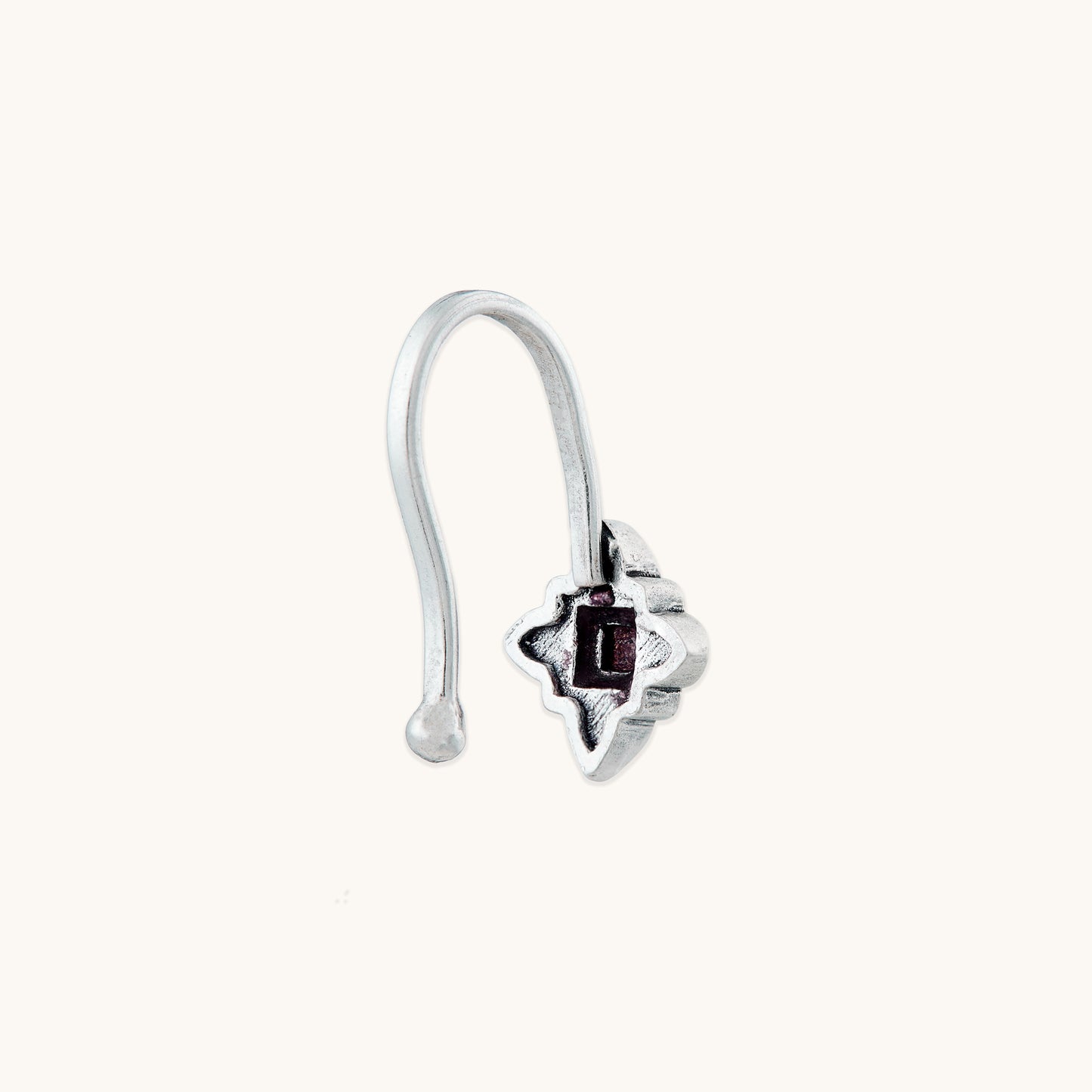 A detailed profile view of a silver-toned, non-piercing nose clip-on, highlighting the smooth hook mechanism and textured metal design.
