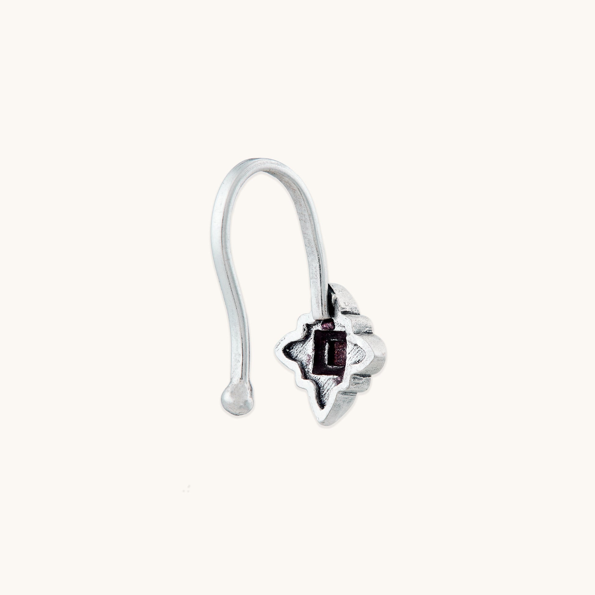A detailed profile view of a silver-toned, non-piercing nose clip-on, highlighting the smooth hook mechanism and textured metal design.