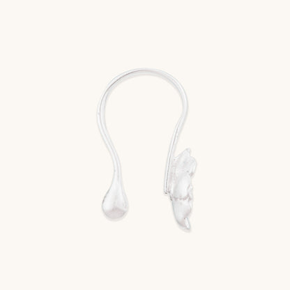 A clear, isolated view of a minimalist silver non-pierced nose ornament, highlighting the smooth curved arm and detailed bloom motif.