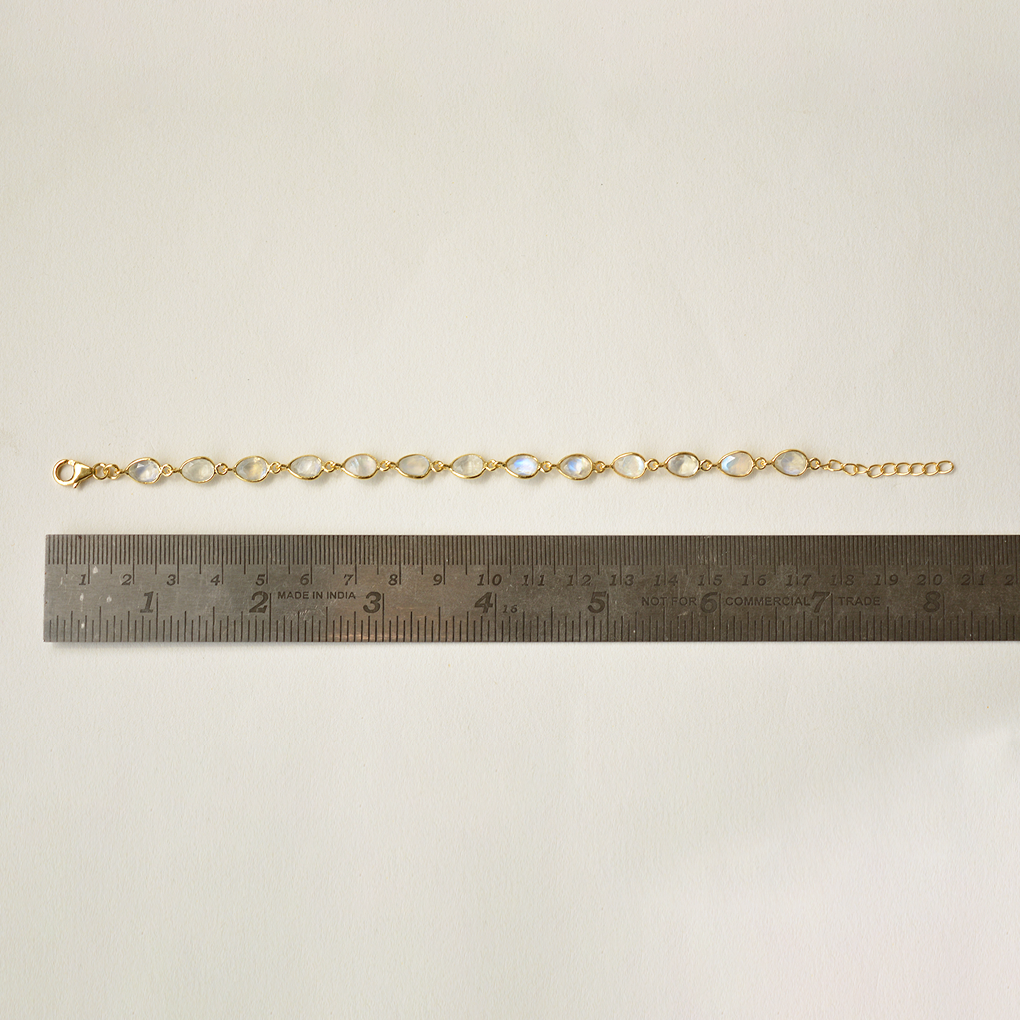 A refined silver link bracelet featuring a central, ethereal glowing gemstone with an adjustable slider clasp.