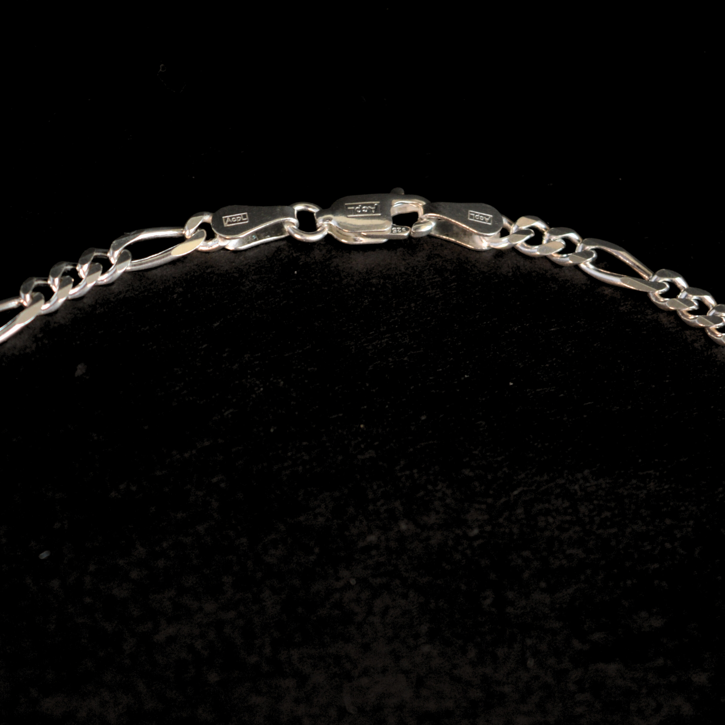Studio shot of a contemporary circular silver necklace piece, emphasizing its clean lines and reflective finish.