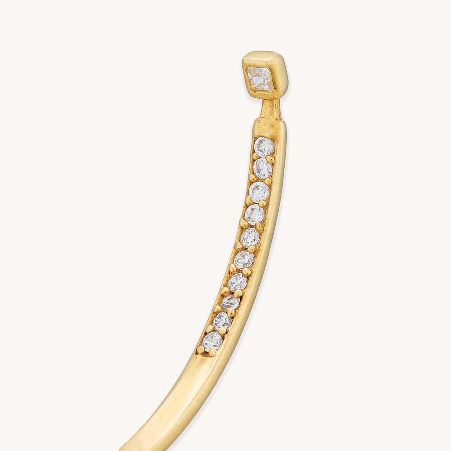 The reverse side of an organic-shaped gold hoop earring, showing smooth, handcrafted detail.