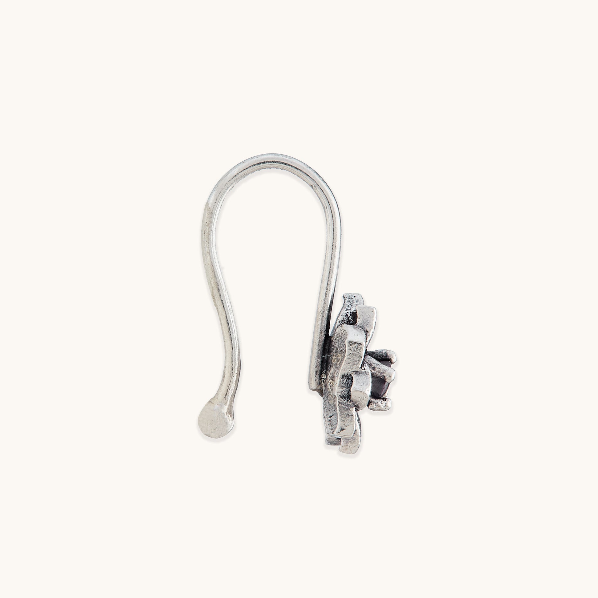 A direct side view of an elegant, non-piercing silver nose ring with an ornate, petal-textured metal casing.