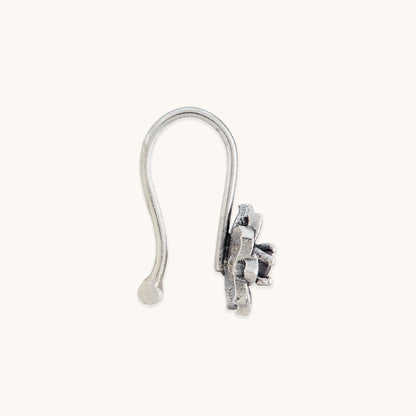 A direct side view of an elegant, non-piercing silver nose ring with an ornate, petal-textured metal casing.