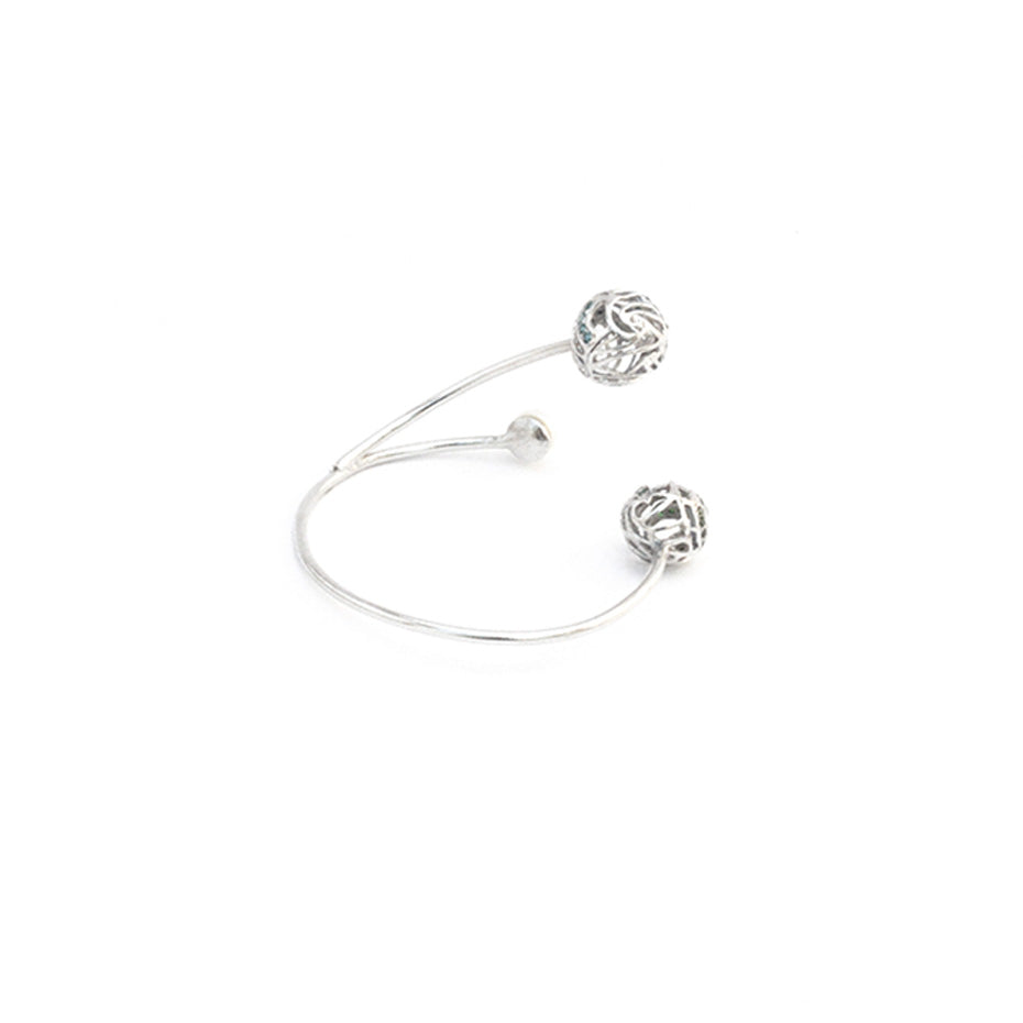 Side view of silver bracelet with white background.