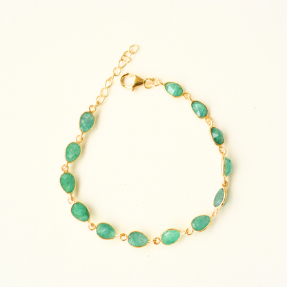 A gold-plated silver chain bracelet featuring multiple oval-cut green beryl stones, photographed against a clean, neutral background.