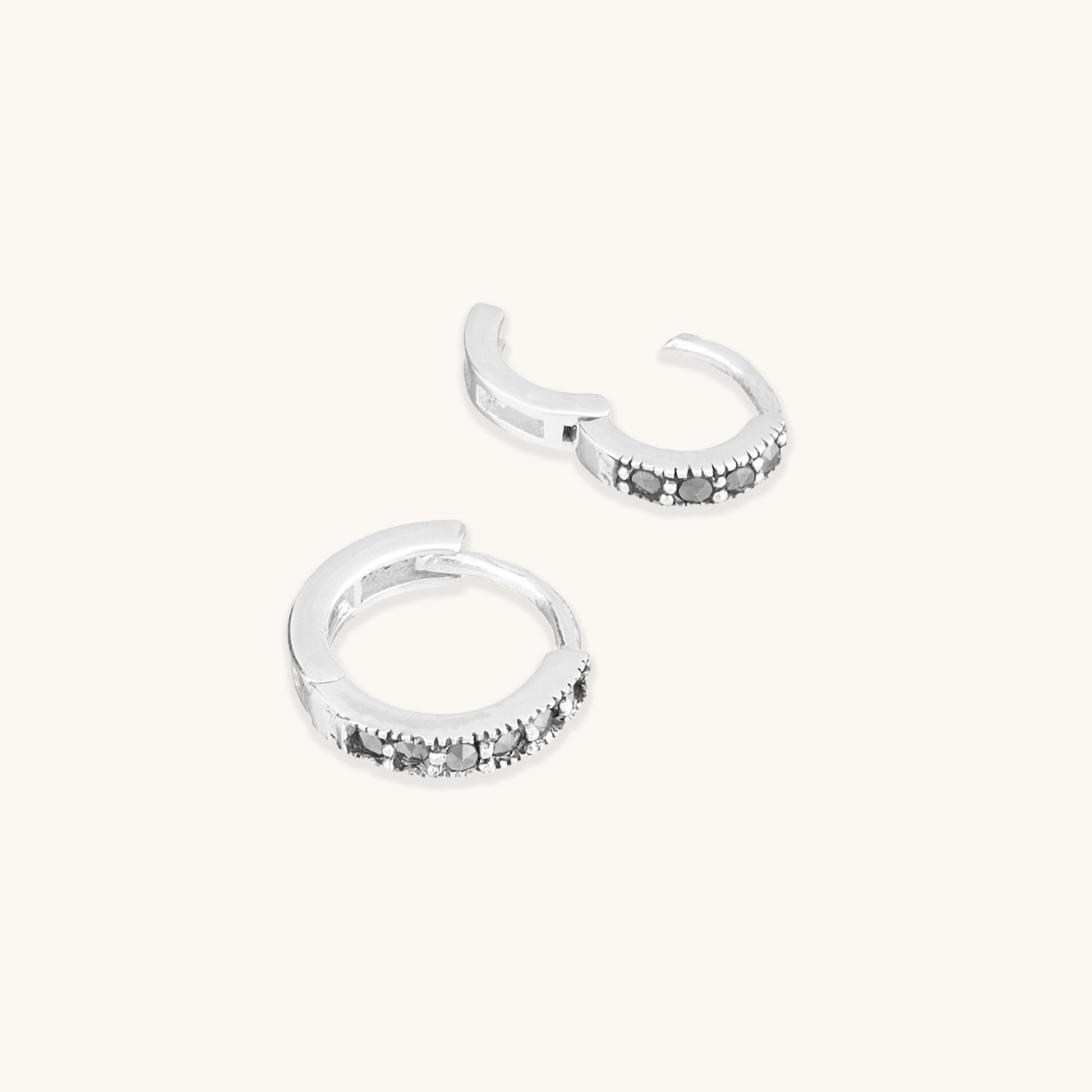 Sterling silver snuggie hoop earrings with black spinel gemstones.