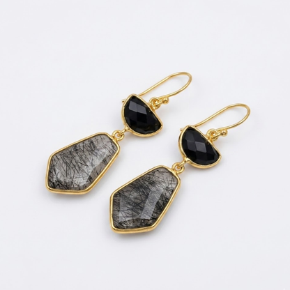Handcrafted 18kt gold-plated sterling silver drop earrings with natural black rutile and onyx stones suspended from a thin branch.