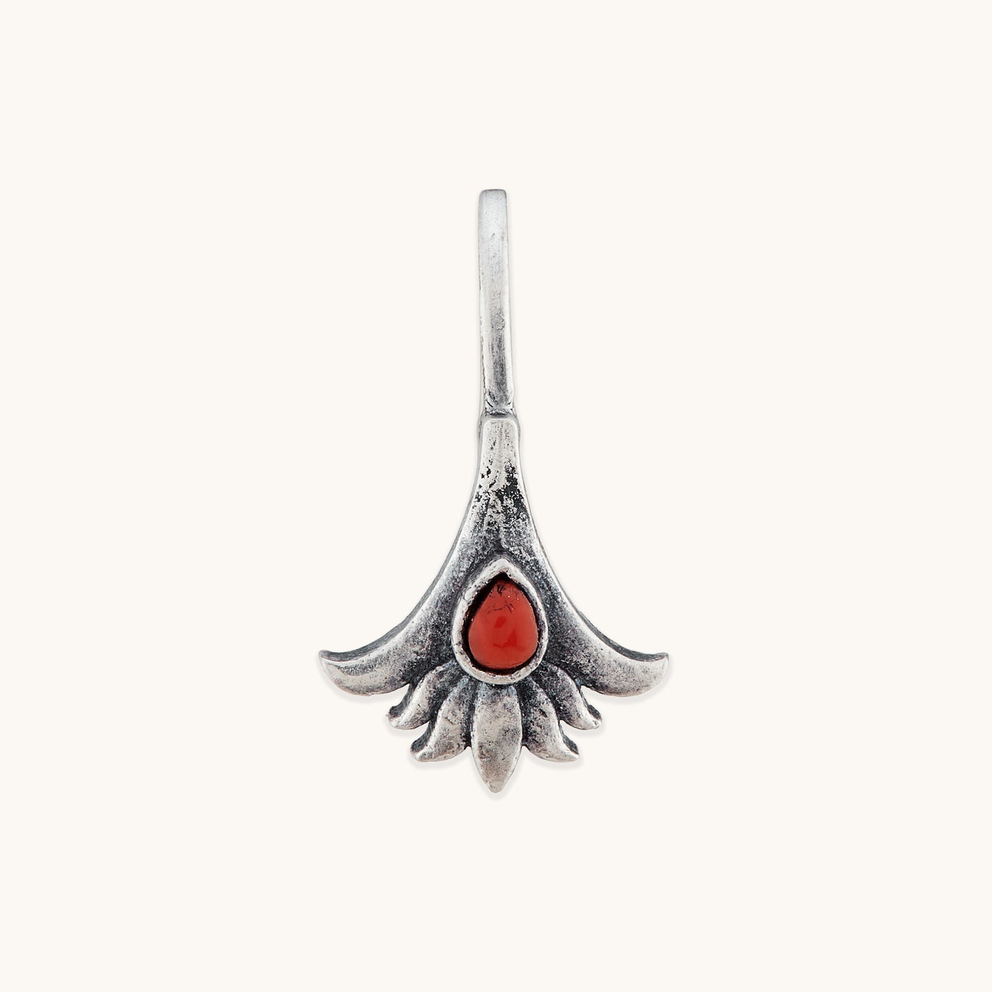 A front-facing studio shot of a symmetrical, floral-themed silver nose clip, showcasing the detailed texture of the metal petals surrounding a vibrant, deep reddish-orange central stone.