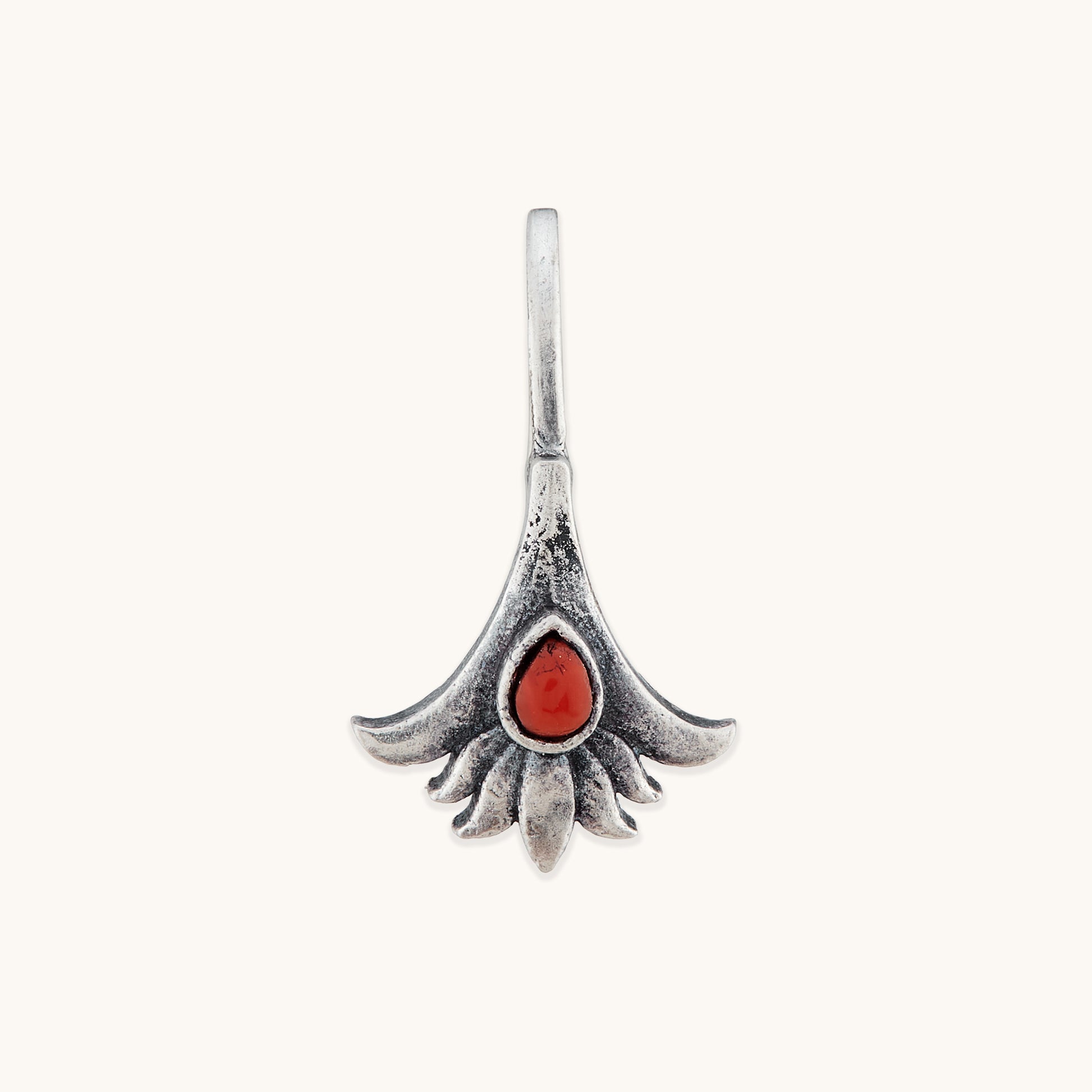 A front-facing studio shot of a symmetrical, floral-themed silver nose clip, showcasing the detailed texture of the metal petals surrounding a vibrant, deep reddish-orange central stone.