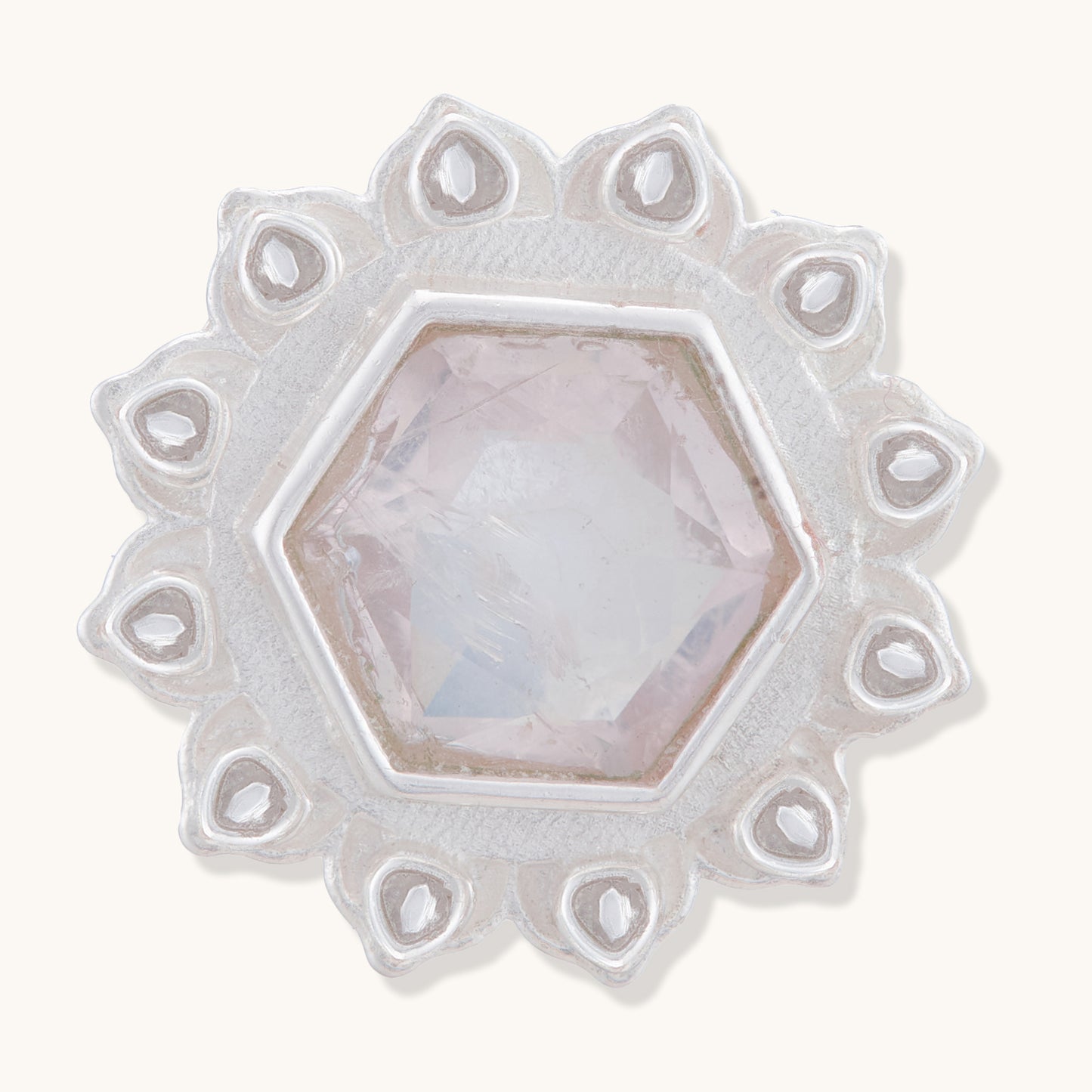 A front view of a silver floral stud earring with a central faceted rose quartz-colored hexagonal stone and intricate petal details.