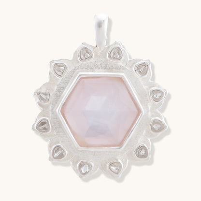 A delicate pendant featuring a soft blush-pink gemstone encased in a sophisticated, intricate silver plated filigree setting.