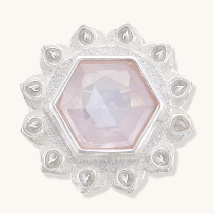 Front view of a silver ring featuring a central hexagonal rose quartz crystal bordered by intricate, teardrop-shaped silver engravings.