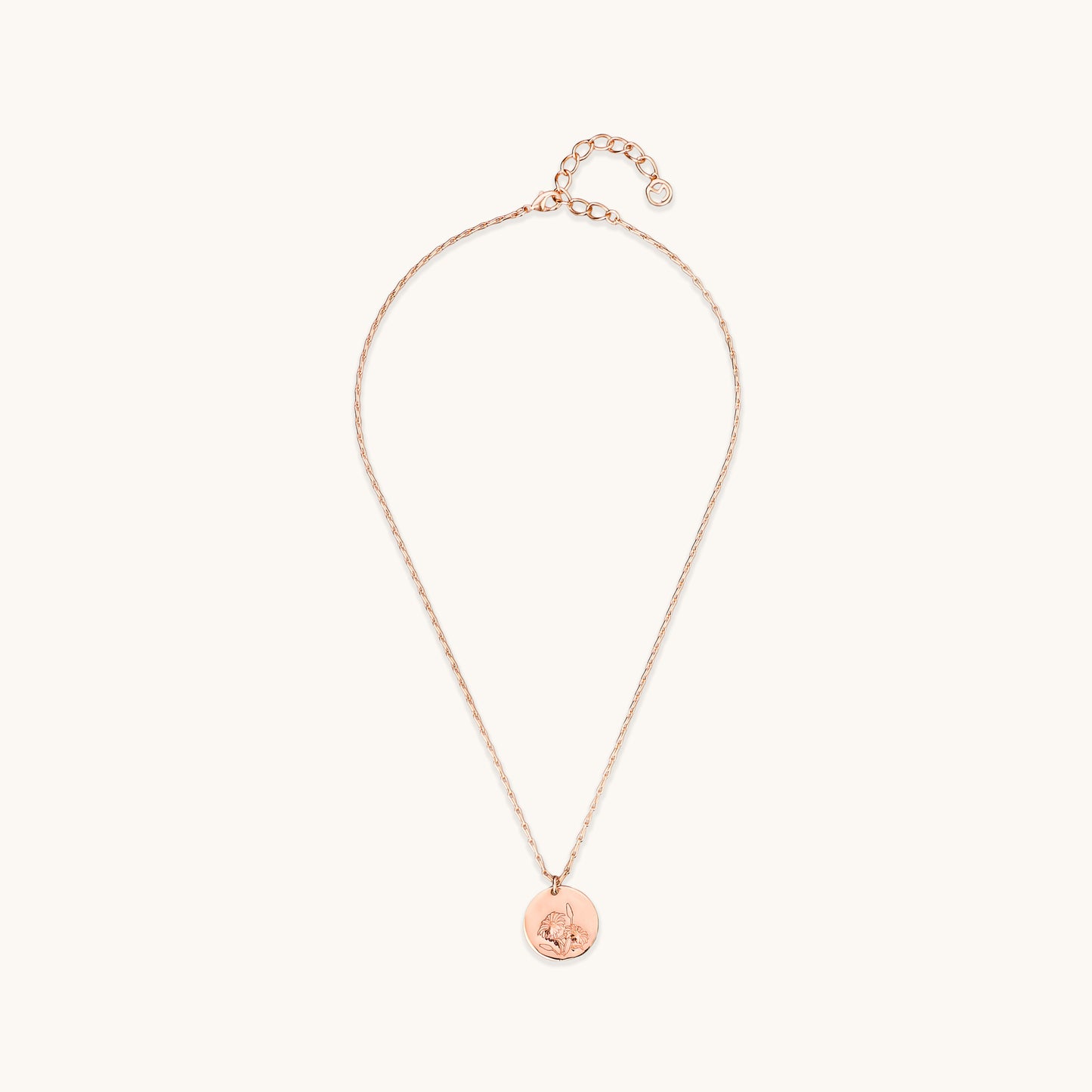 Full view of the Daisy Medallion Necklace, featuring a rose gold circular pendant with an engraved floral daisy design on a delicate link chain.