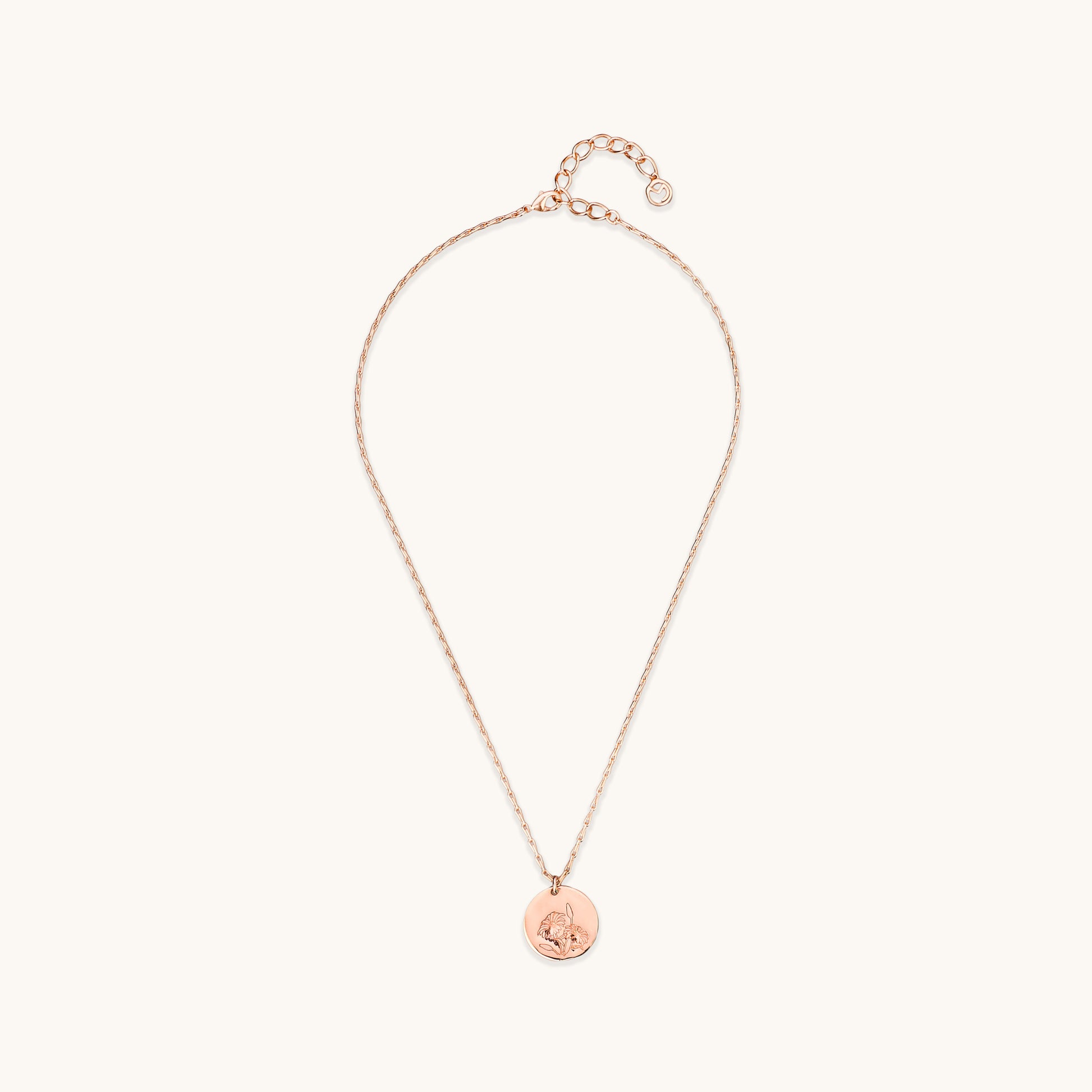 Full view of the Daisy Medallion Necklace, featuring a rose gold circular pendant with an engraved floral daisy design on a delicate link chain.