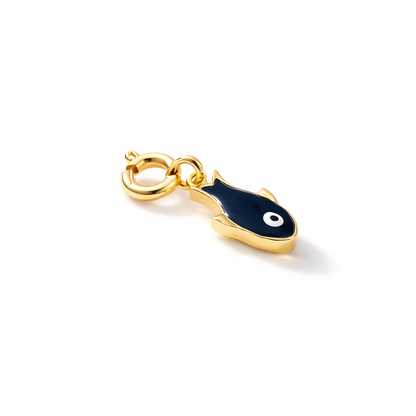 A studio shot of a gold-plated charm shaped like a stylized fish, finished with glossy navy blue enamel and a circular white eye accent, attached to a small spring ring clasp.