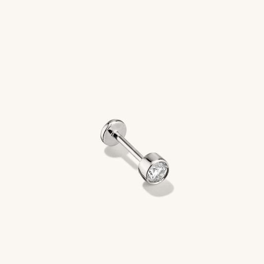 Silver flat back stud earring featuring a round  clear gemstone.
