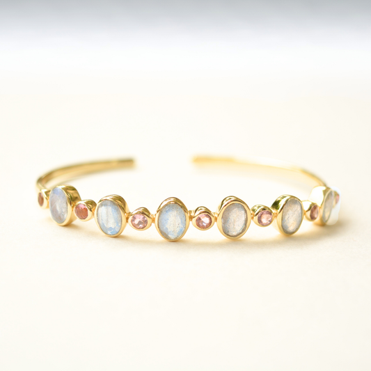 Open-ended sterling silver cuff bracelet featuring a faceted purple stone and an iridescent labradorite stone at each end.