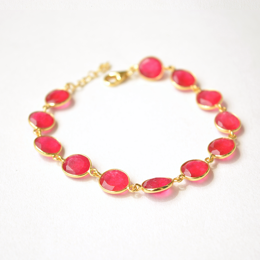 Dainty sterling silver chain bracelet featuring a smooth, round pink stone set in an open-back gold-tone bezel.