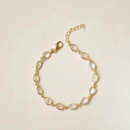 Dainty sterling silver chain bracelet featuring an iridescent, glowing gemstone charm in an open bezel setting.