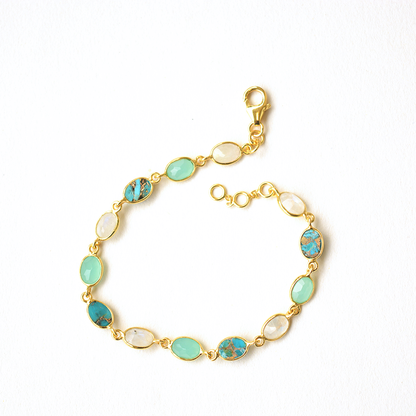 Dainty sterling silver chain bracelet featuring a gradient of faceted blue gemstones in open bezel settings.