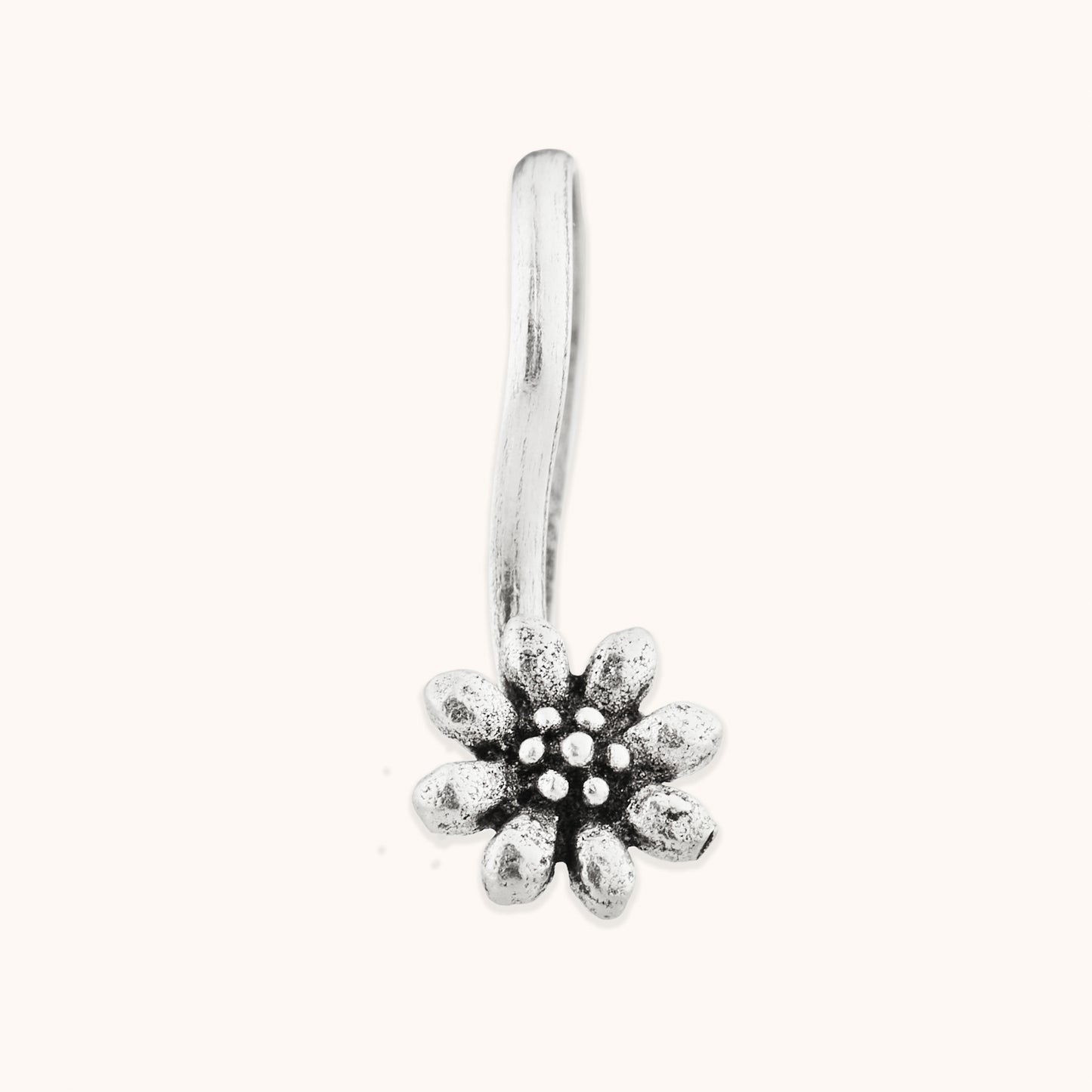 A front-facing view of a decorative, blossom-themed silver nose clip, highlighting the fine texture and precision of the floral-inspired metalwork.