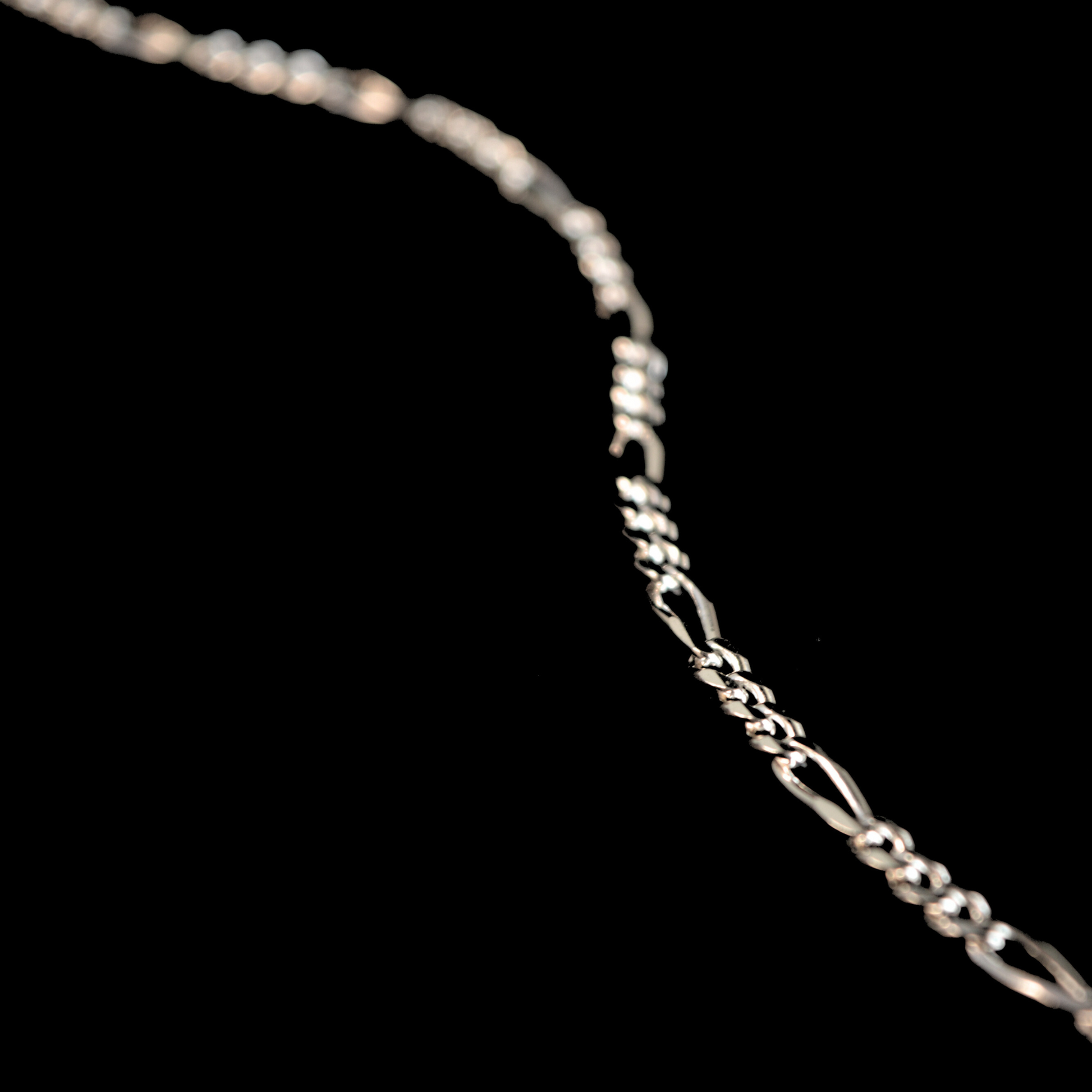 Close-up view of a high-shine silver loop chain, showcasing its smooth, rounded surface and timeless, versatile design.