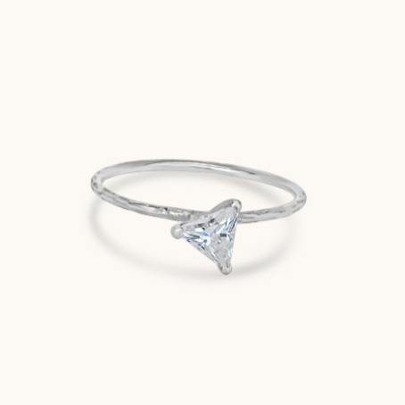 A handcrafted sterling silver band plated in platinum for a lasting shine, featuring a brilliant, prong-set 3mm trillion cubic zirconia stone that captures light from every angle, isolated on a white background.