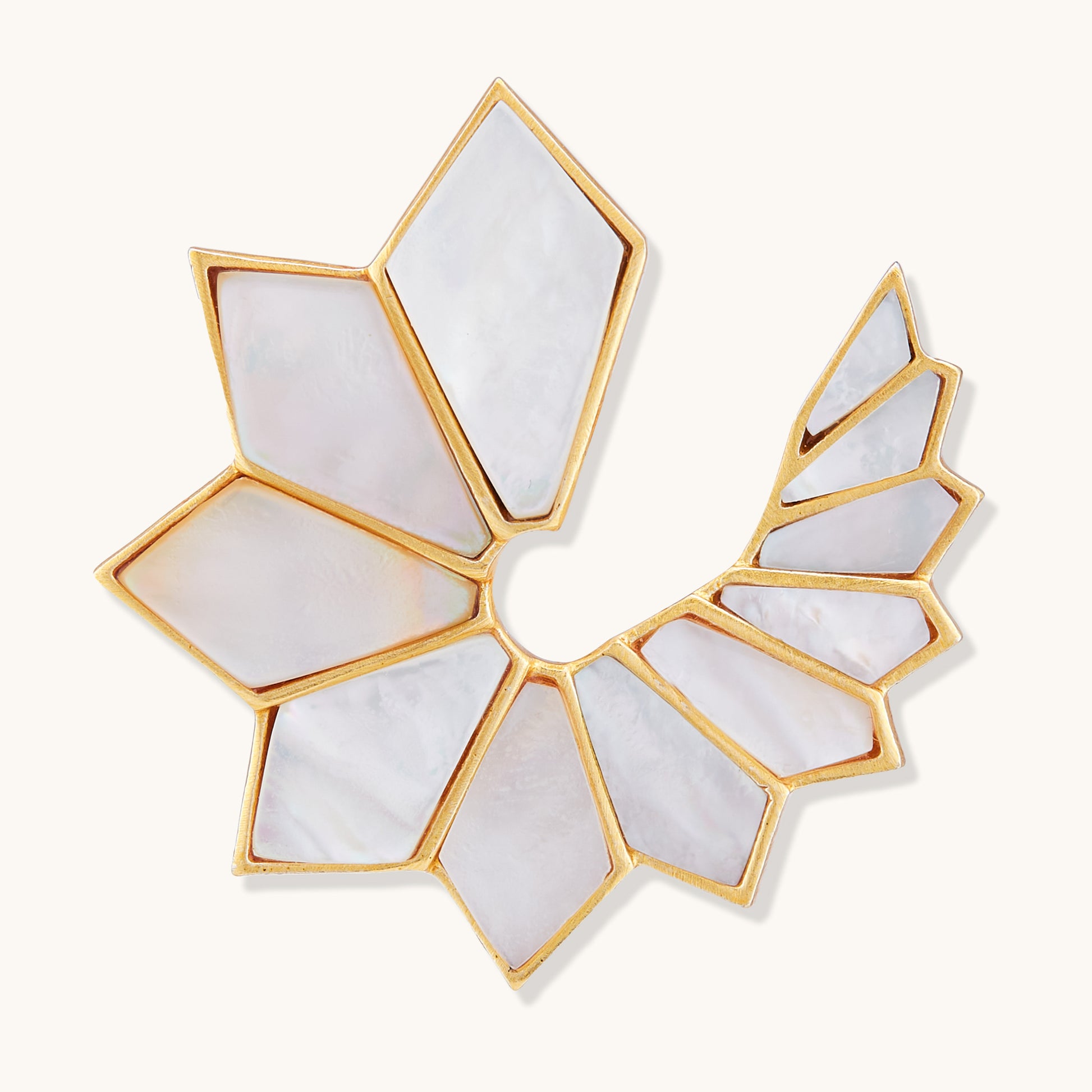 Abstract fan-shaped statement earring featuring geometric white pearl inlays set in a gold-toned frame.