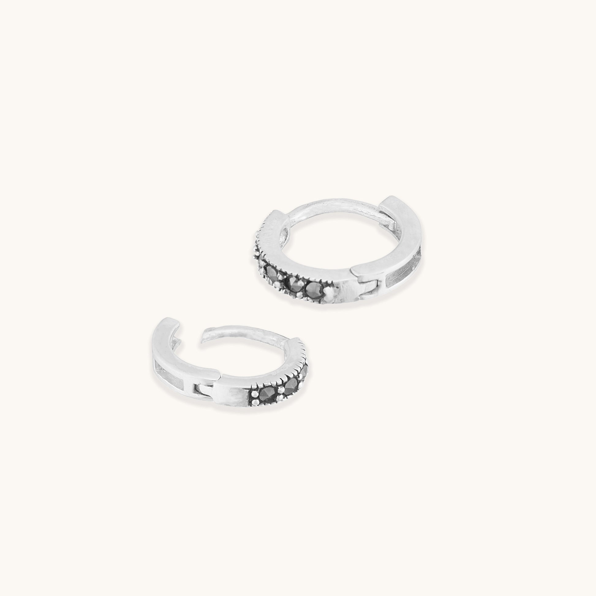 Featuring a row of pave-set dark grey or black stones along the front edge.