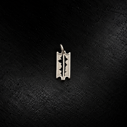 Front view of the small Mountains Are My Lifeline 925 silver razor-edge pendant on dark stone