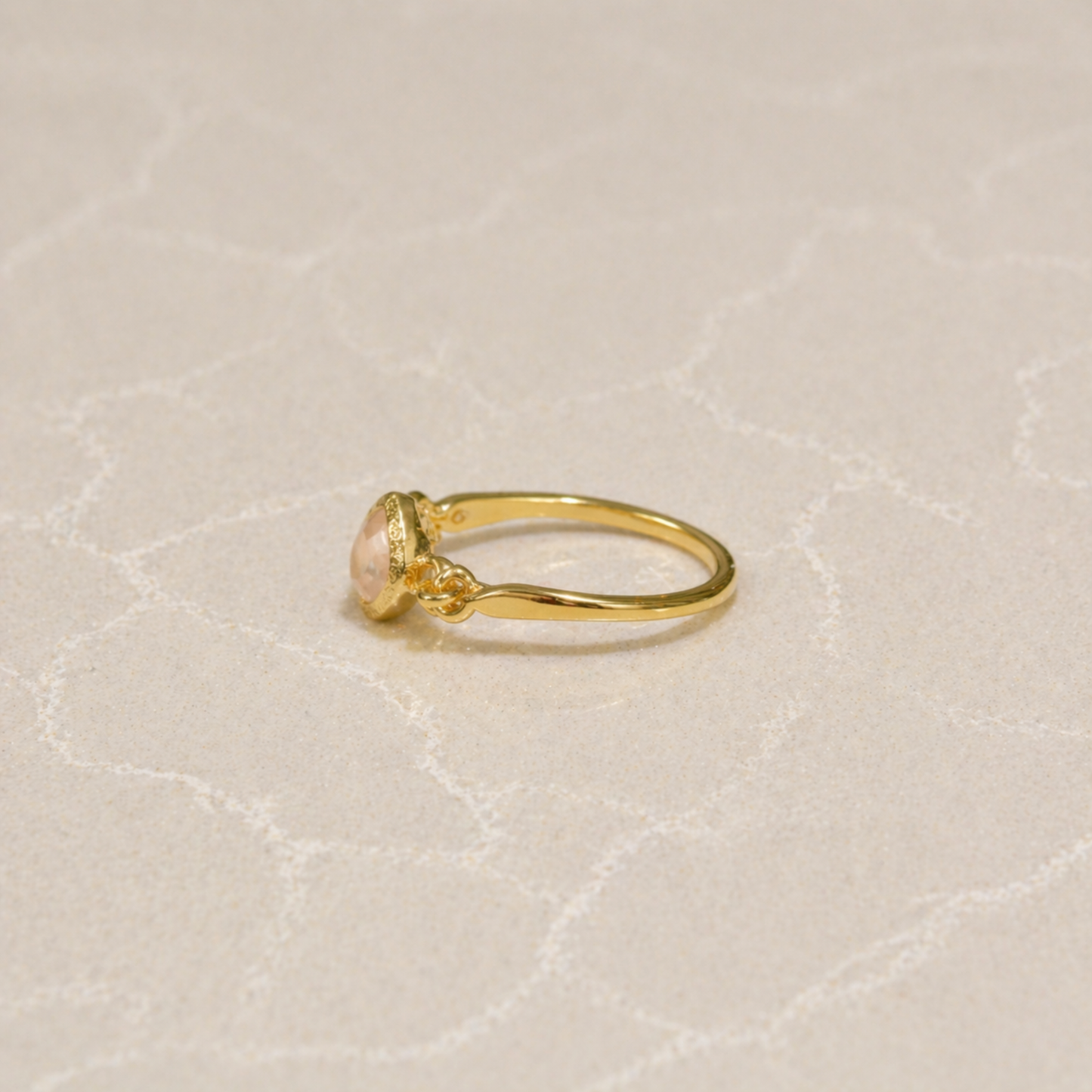 Side view of the Blush Glow Ring showing the polished 18kt gold plating over 925 sterling silver and the delicate setting of the square rose quartz.