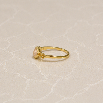 Side view of the Blush Glow Ring showing the polished 18kt gold plating over 925 sterling silver and the delicate setting of the square rose quartz.