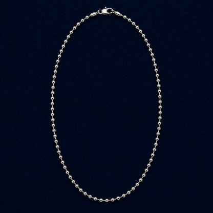 A full studio shot of the handcrafted Everyday Soft Glow necklace in 925 sterling silver, featuring a long, high-polish beaded ball chain design on a dark navy background.