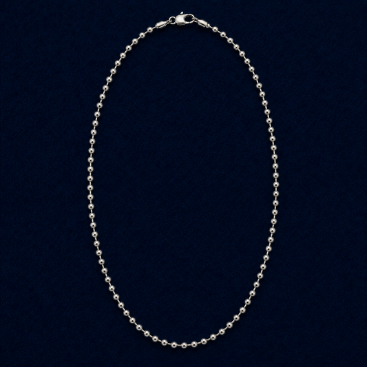 A full studio shot of the handcrafted Everyday Soft Glow necklace in 925 sterling silver, featuring a long, high-polish beaded ball chain design on a dark navy background.