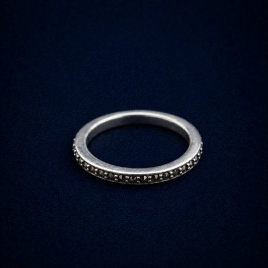 A detailed perspective shot of the Everyday Sparkle Ring, displaying the shimmering cubic zirconia stones set into a thin, modern sterling silver eternity-style band.