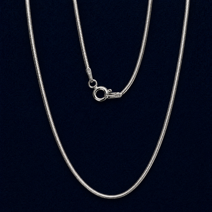 A long  handcrafted 925 sterling silver flat snake chain necklace displayed in a vertical layout, showing its fluid movement and sleek polished finish against a dark background.