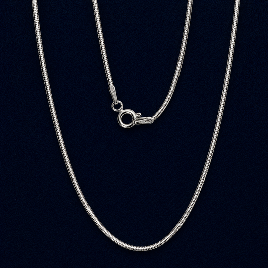 A long  handcrafted 925 sterling silver flat snake chain necklace displayed in a vertical layout, showing its fluid movement and sleek polished finish against a dark background.