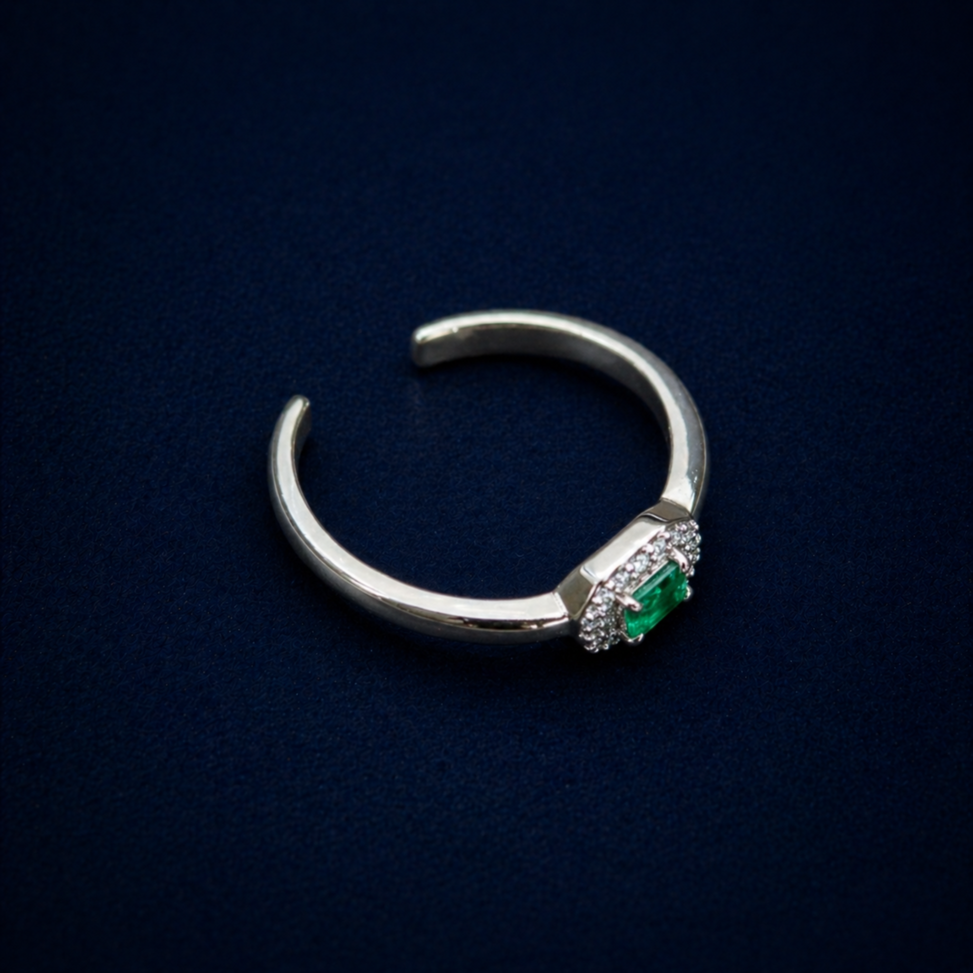Perspective shot of the Evergreen Spark Ring highlighting the vibrant green cubic zirconia center stone and the modern octagonal halo of clear CZ stones.