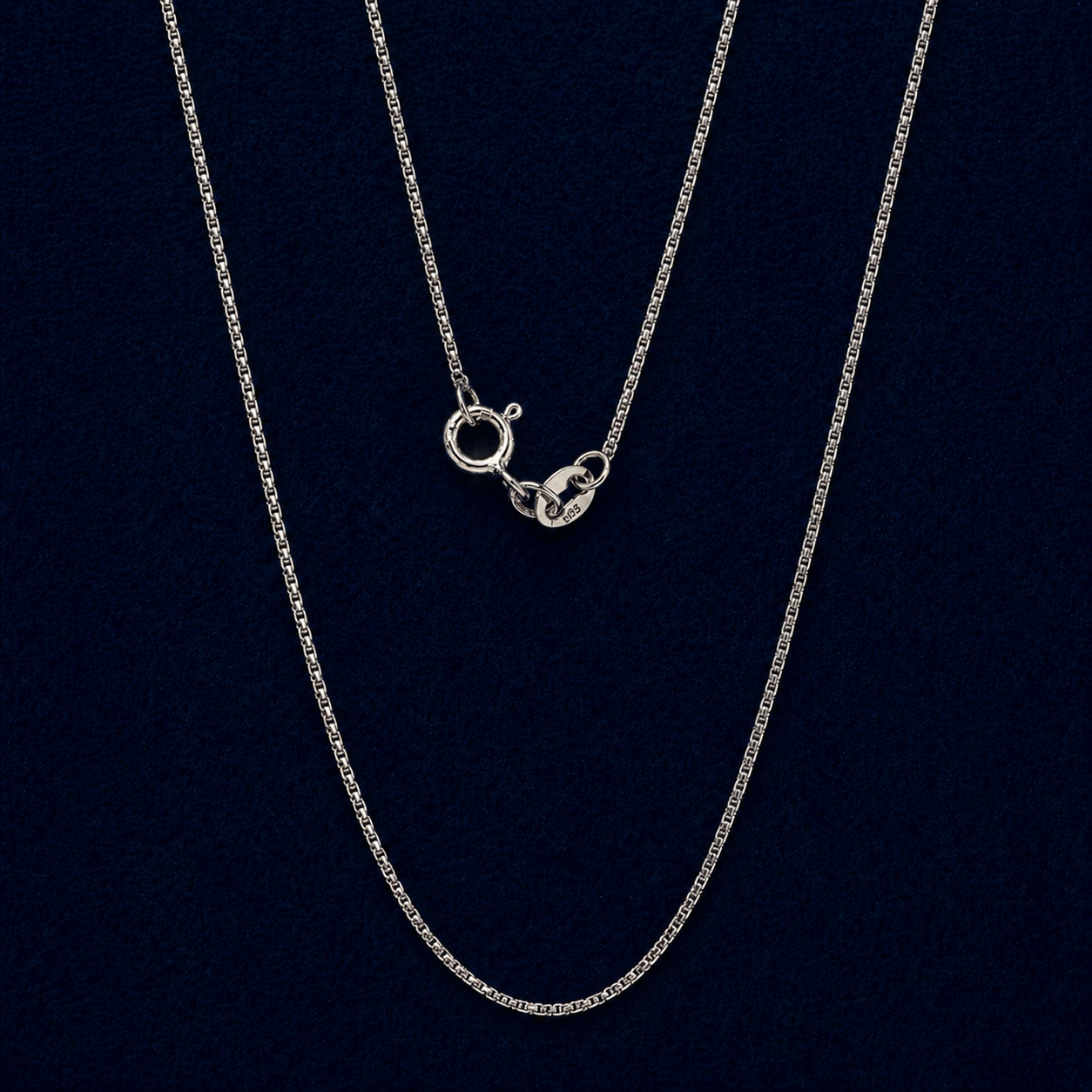 A full view of the handcrafted 925 sterling silver Gridline Chain, featuring delicate small square-shaped links and a neat, structured design against a dark navy background.