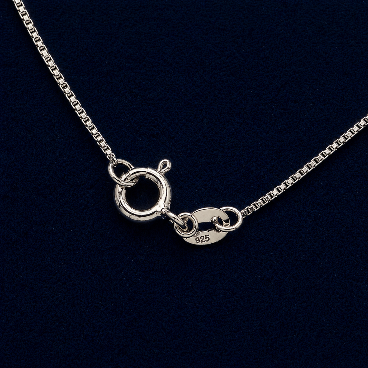 Macro close-up of the Gridline Chain, showcasing the delicate 925 sterling silver square links, the secure lobster clasp, and the polished end tab on a dark, textured surface.