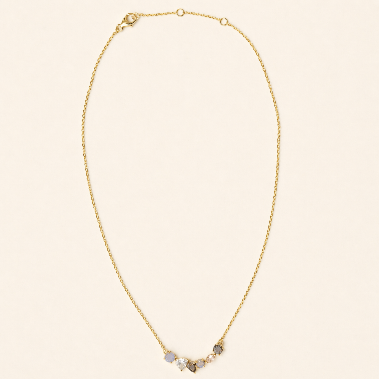 Full studio shot of the Soft Harmony necklace on a white background, displaying the elegant stone cluster design and the adjustable 18kt gold plated lobster clasp.